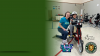student on bike with teacher standing next to them