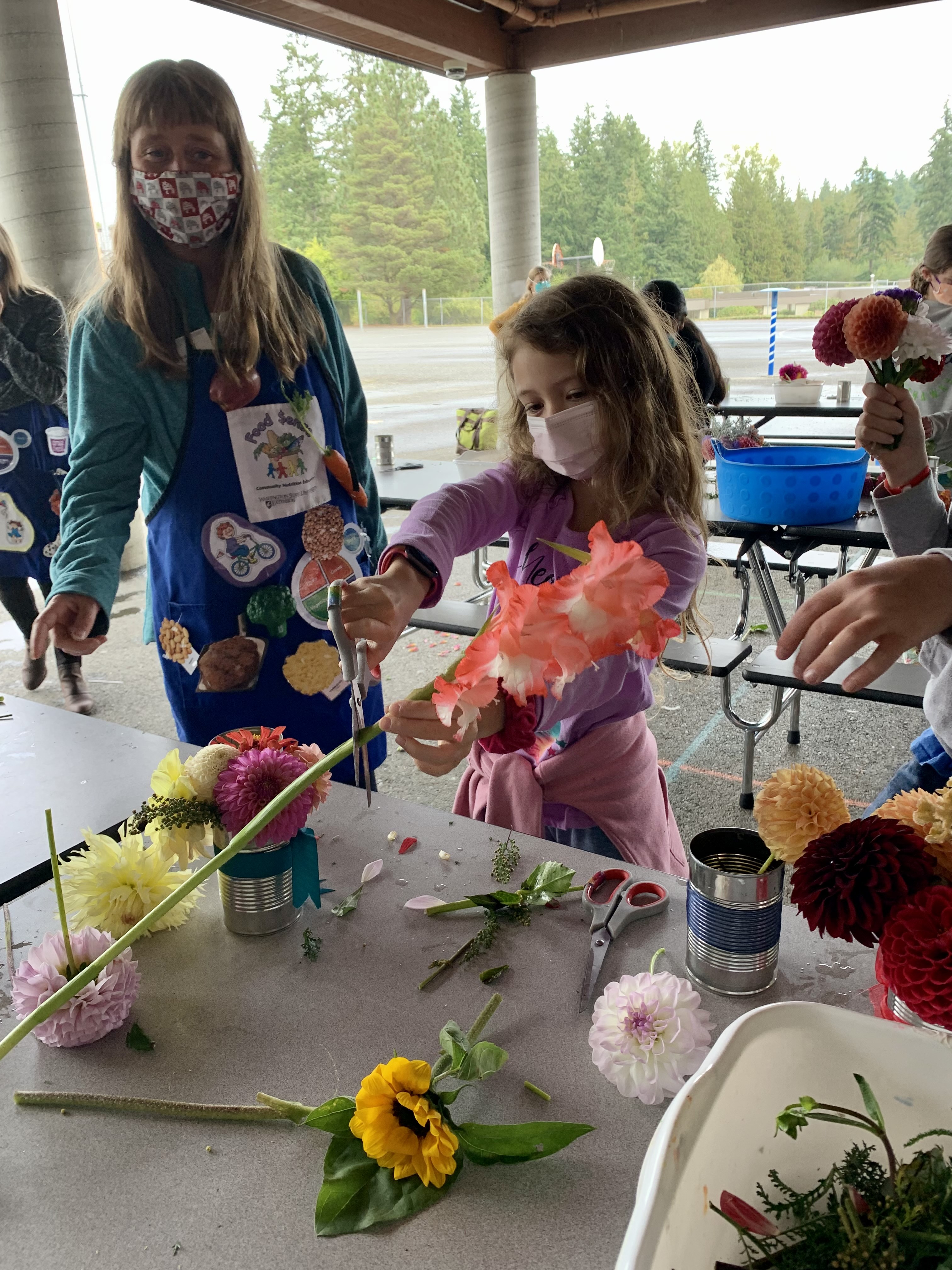 Student learning how to cut stems off flowers for arrangements.