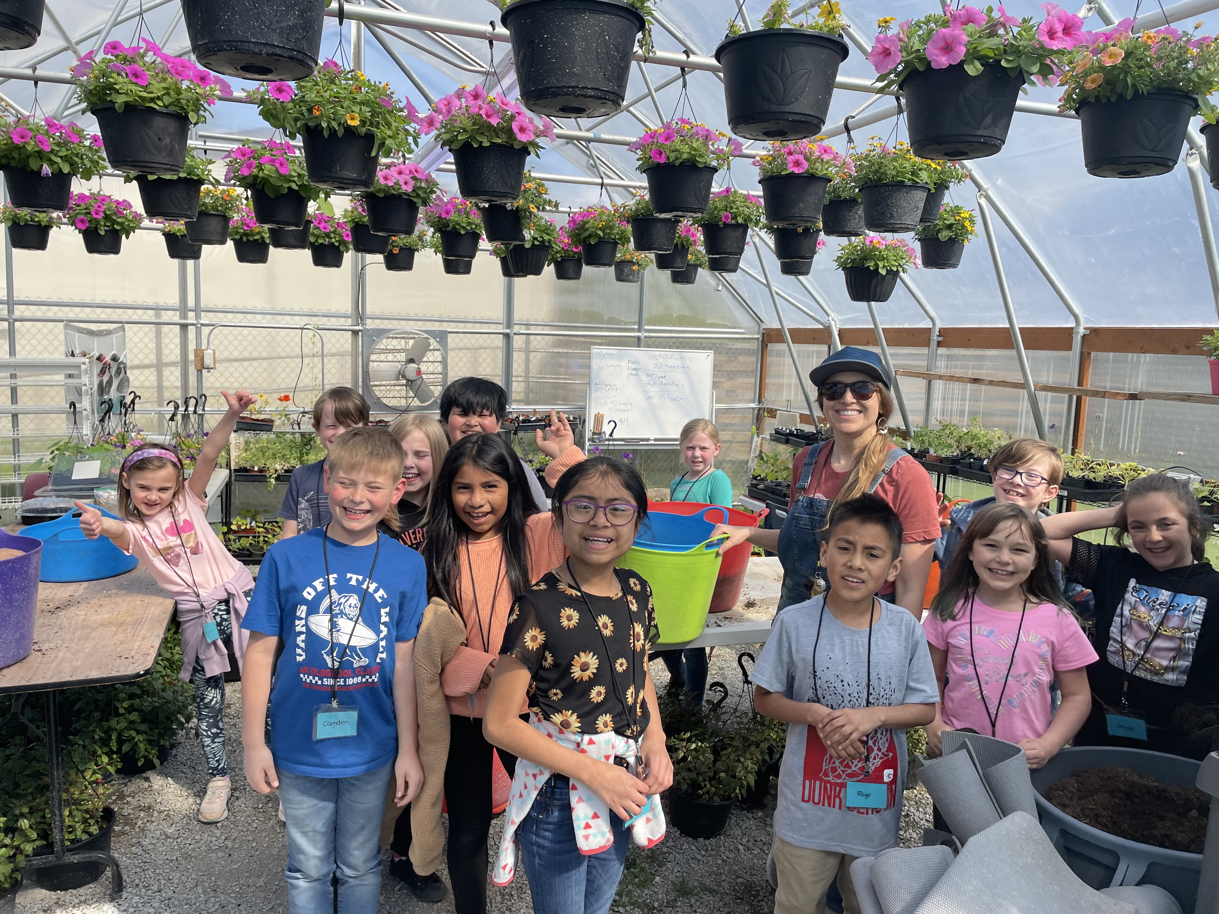 Image of students posing inside a greenhouse.